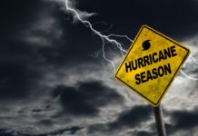 Hurricane season with symbol sign against a stormy background and copy space. Dirty and angled sign adds to the drama.