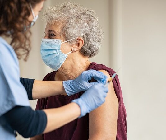 Doctor Giving Covid Vaccine To Senior Woman