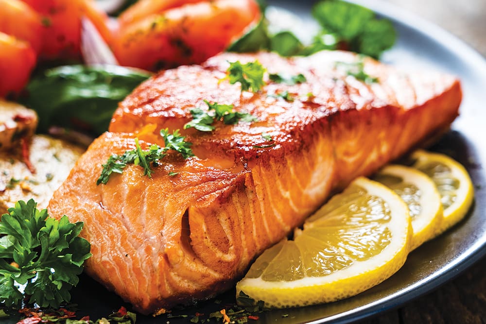 Barbecued Salmon, Fried Potatoes And Vegetables On Wooden Background