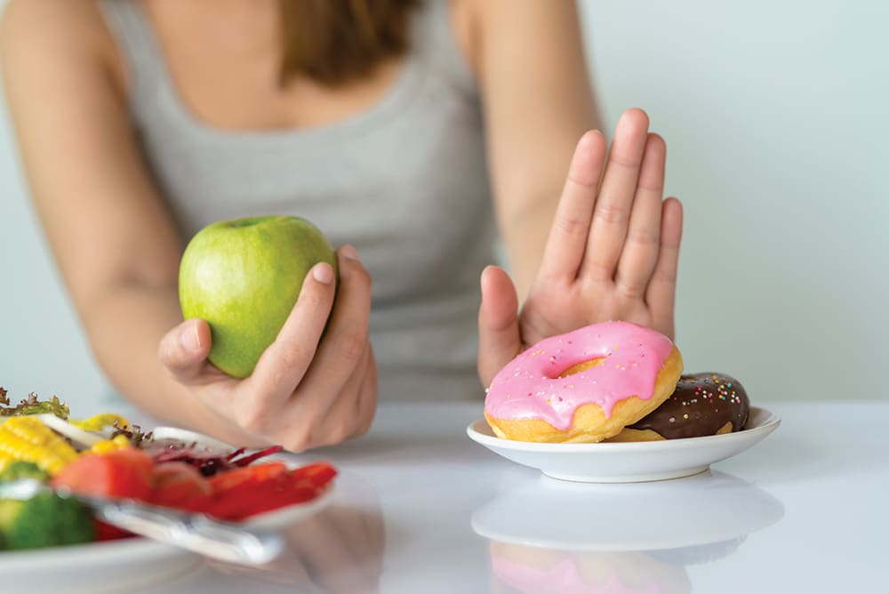 Dieting Or Good Health Concept. Young Woman Rejecting Junk Food Or Unhealthy Food Such As Donut Or Dessert And Choosing Healthy Food Such As Fresh Fruit Or Vegetable.