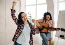 Funny Women Play The Guitar And Dancing At Home