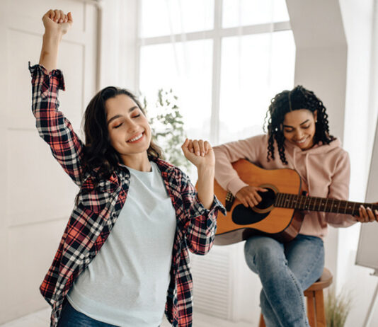 Funny Women Play The Guitar And Dancing At Home