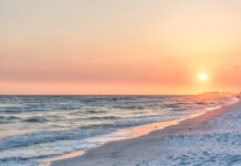 Dreamy Pink Peach Orange Sunset In Santa Rosa Beach, Florida With Pensacola Coastline Coast Cityscape Skyline In Panhandle With Ocean Gulf Mexico Waves, Birds