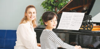 Private Music Teacher Giving Piano Lessons To Little Boy