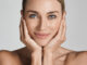 Skin Care. Beautiful Woman With Healthy Facial Skin Touching Hands Moisturized Face Skin, On Light Grey Background. High Quality