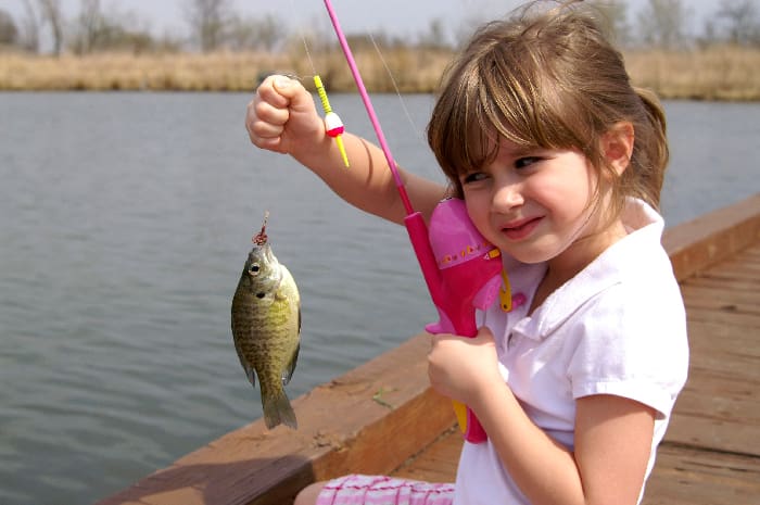 A Little Girl Caught A Fish On A Wooden Boat
